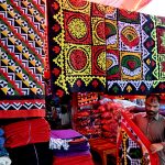 A vendor displaying handmade bed sheets to attract the customers at Jilis Bazaar