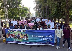 Students hold placards during an event organized by the Institute of Food Science and Nutrition at the University of Sargodha in connection with World Food Day