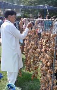 A vendor arranging and displaying key chains to attract the customers.