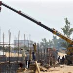 Labourers are busy construction work of T-Chowk Flyover using heavy machinery during development work