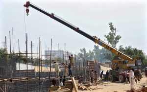 Labourers are busy construction work of T-Chowk Flyover using heavy machinery during development work