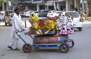 A street hawker wandering along the roadside to sell colourful balloons to earn for livelihood at satellite market