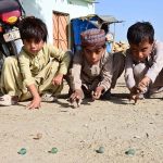 Children play marbles a traditional game to spend their leisure time in Latifabad