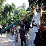 Children enjoying slide swing at Jinnah Park.