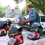 A local vendor is displaying motorcycle helmet on his cart to attract the customers at DPO office Chowk.