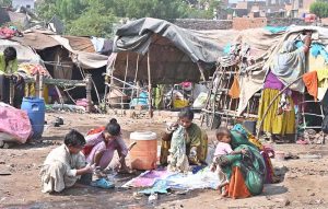 Gypsy women busy in washing the clothes in front of their hut near Railway Station area.