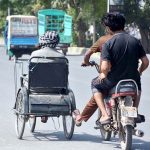 A motorcyclists pushing a disabled man's wheelchair help him to reach his destination