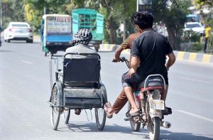 A motorcyclists pushing a disabled man's wheelchair help him to reach his destination
