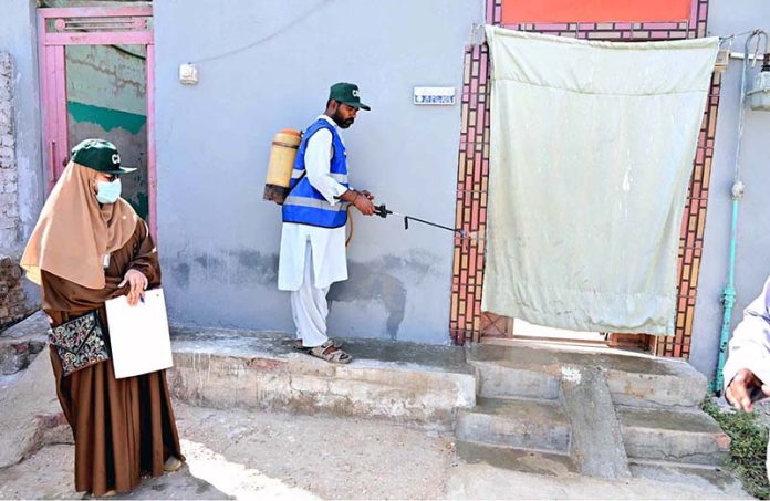 CBH worker spraying anti-dengue chemical outside a house at Kumhar Para