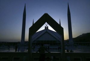 A breathtaking view of Faisal Mosque at sunset, with the sun setting behind the Margalla Hills, creating a serene and spiritual ambiance in the Federal Capital.