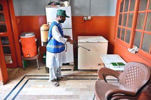 CBH worker spraying anti-dengue chemical outside a house at Kumhar Para