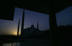 A breathtaking view of Faisal Mosque at sunset, with the sun setting behind the Margalla Hills, creating a serene and spiritual ambiance in the Federal Capital.