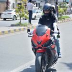 A woman rides a heavy bike in the city