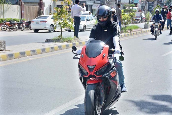 A woman rides a heavy bike in the city
