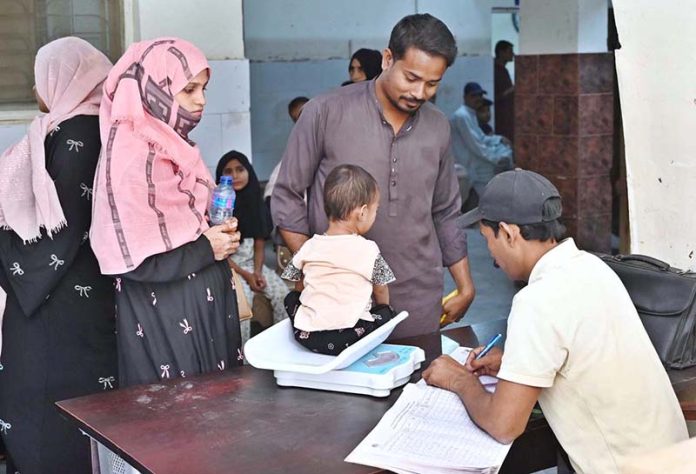 A medical staffer weighting a child at Bhitai Hospital