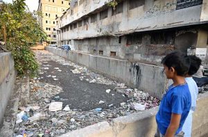 Children look at an unclean nullah filled with garbage and waste at Akbar Road, posing serious health risks for local residents and drawing the attention of the concerned authorities.