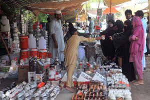 Women busy purchasing various household items from vendor at the weekly Bazaar.