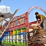 Laborers loading scrap on delivery truck
