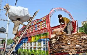 Laborers loading scrap on delivery truck
