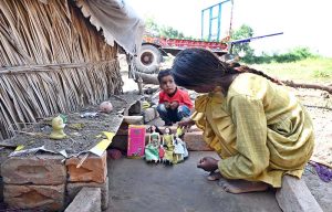 A girl and his brother playing with dolls at Jhang Road.