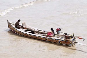 Fisherman preparing fishing net for fishing while sitting on the boat at Indus River.