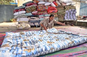 A worker busy in stitching a quilt for customers at his workplace in Federal Capital.