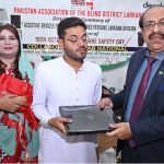 Director General Sindh Pakistan Association of the Blind Ghulam Farooq Laghari distributing laptops to visually impaired person during a ceremony on the occasion of International White Cane Safety Day, organized by the Pakistan Association of the Blind District Larkana at Begum Nusrat Bhutto Auditorium Hall Jinna Bagh