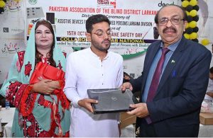 Director General Sindh Pakistan Association of the Blind Ghulam Farooq Laghari distributing laptops to visually impaired person during a ceremony on the occasion of International White Cane Safety Day, organized by the Pakistan Association of the Blind District Larkana at Begum Nusrat Bhutto Auditorium Hall Jinna Bagh