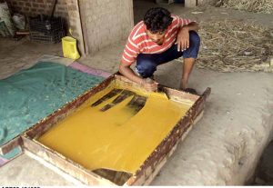 Worker busy preparing gur (jaggery) from the fresh sugarcane crop along Chiniot–Lahore Road.