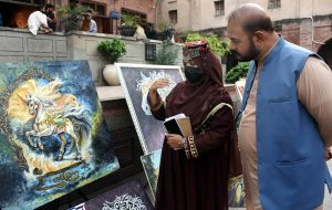 Visitors viewing a painting and calligraphy exhibition at Masjid Wazir Khan Square, organized in collaboration with The Knowledge of Art Academy and the Walled City of Lahore Authority.