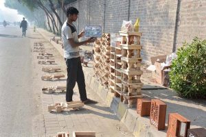 A vendor arranges and displays colorful toys at his roadside stall to attract customers and earn a livelihood for his family.