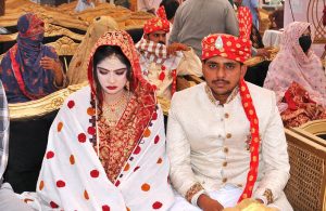 Brides in a group photo during a mass marriage ceremony held under the “Punjab Dhee Rani Program” at Sports Ground.