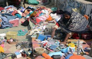 A woman vendor sells used household items at his roadside setup in the Provincial Capital.