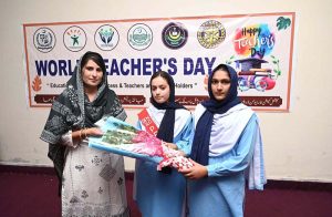 Students are presenting flowers bouquet to teacher to greet her on the occasion of World Teachers' Day during a seminar held at DPS School and College.
