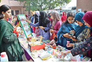 Students take interest in handmade embroidered items displayed at different stalls during the two-day Sports Gala at Women University, Katchery Campus.