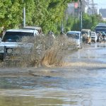 Commuters wade through stagnate rainwater in Korangi, a day after heavy rains lashed the city.