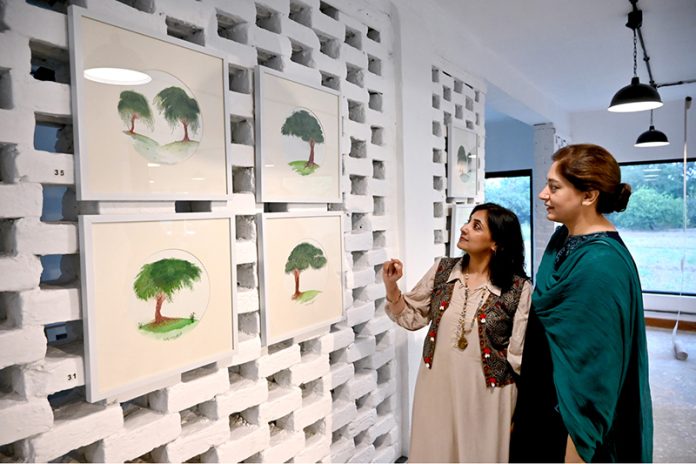 Women viewing the exhibition “Tree for Life”, a solo show by Farrah Mahmood, at FMR Art & Culture Gallery