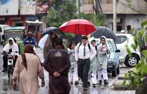 Students on the way under cover of umbrellas to protect from rain that experienced the Federal Capital.