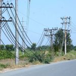 Electric wires hang dangerously low from poles along Millat Road, posing a serious risk of accidents