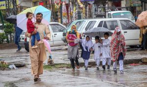 Students on the way under cover of umbrellas to protect from rain that experienced the Federal Capital.