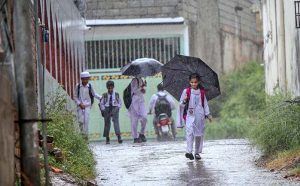 Students on the way under cover of umbrellas to protect from rain that experienced the Federal Capital.