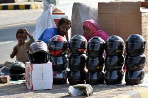 A family selling helmets to motorists at their roadside setup on Walton Road.