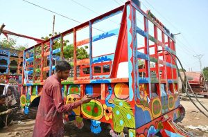 A worker busy in coloring tractor trolley at Central Jail Road.