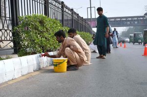 PDA workers busy in painting the main G.T road footpath at Gulbahar area.