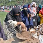A student making clay pot on stall during Zarai Mela at University of Agriculture Faisalabad (UAF)