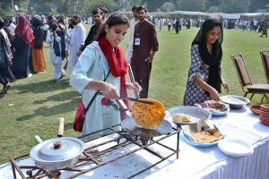 A student making clay pot on stall during Zarai Mela at University of Agriculture Faisalabad (UAF)