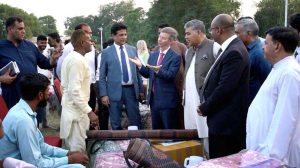 Senator Khalil Tahir Sandhu in a group photo with foreign dignitaries during a relief goods distribution ceremony in Sialkot.
