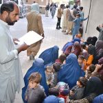 Police personnel registers the names and details of Afghan nationals detained by the district administration for residing illegally