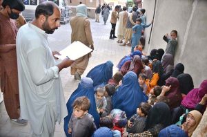 Police personnel registers the names and details of Afghan nationals detained by the district administration for residing illegally