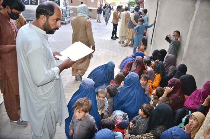 Police personnel registers the names and details of Afghan nationals detained by the district administration for residing illegally